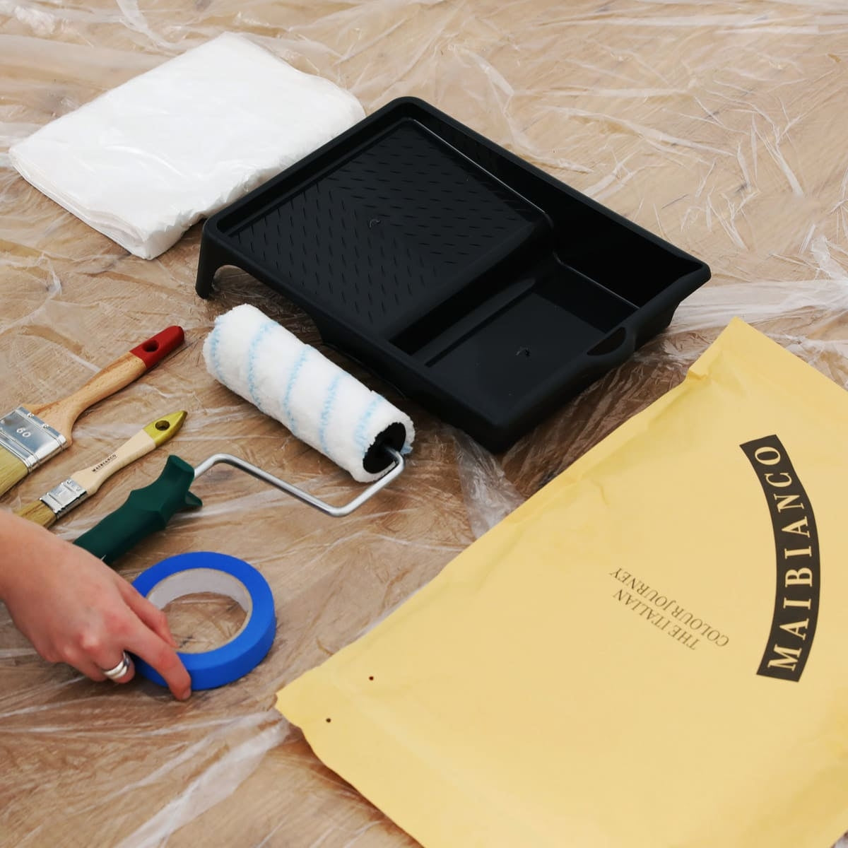 Kit completo per imbiancare con rullo, pennelli, nastro e vaschetta su telo copritutto