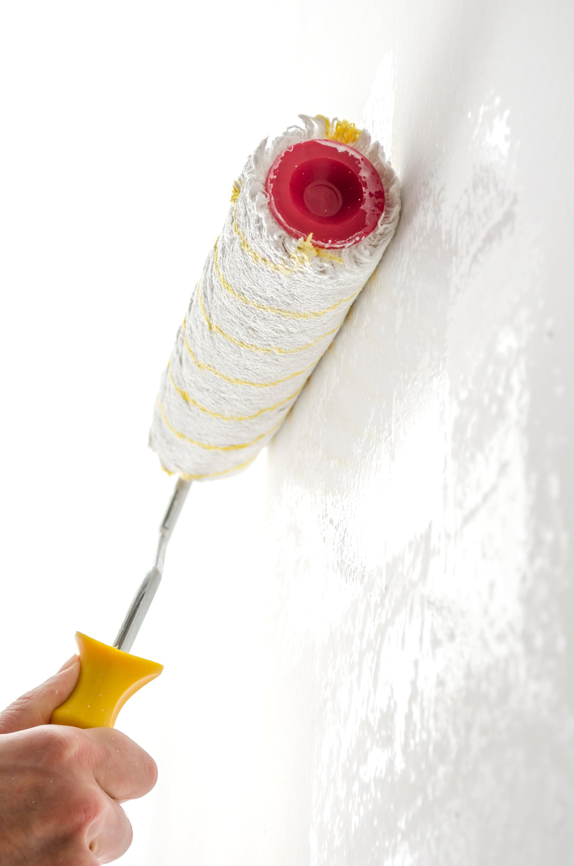 Applicazione di primer fissativo Maibianco con rullo su parete interna bianca.